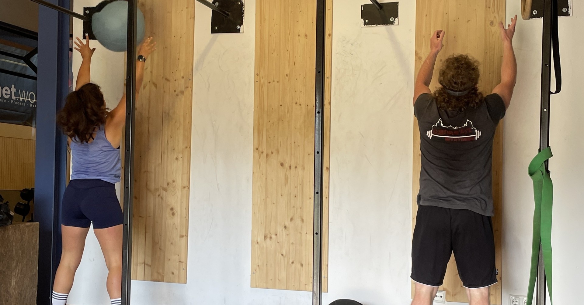 Zwei Personen beim Wall Ball Training im Fitnessstudio
