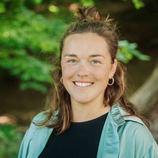 Alea Portrait 2024 – Frau im Grünen mit türkisfarbener Jacke Alea Portrait im Grünen, Frau mit langen braunen Haaren und türkisfarbener Jacke