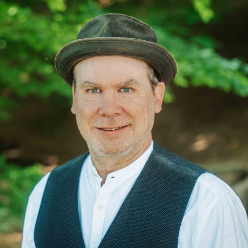 Alea Portrait S 38 – Mann mit Hut und Weste vor Naturhintergrund Alea Portrait eines Mannes mit Hut und Weste im Grünen