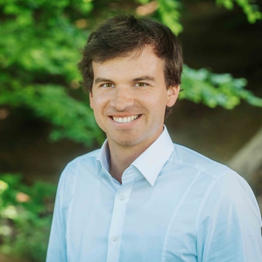 Alea Portrait S-12 – Person im weißen Hemd vor Natur Alea Portrait einer Person im weißen Hemd vor grünem Hintergrund