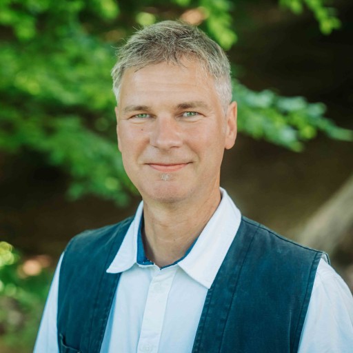 Alea Portraitfoto im Grünen mit weißem Hemd und dunkler Weste Portrait von Alea im Freien mit weißem Hemd und dunkler Weste