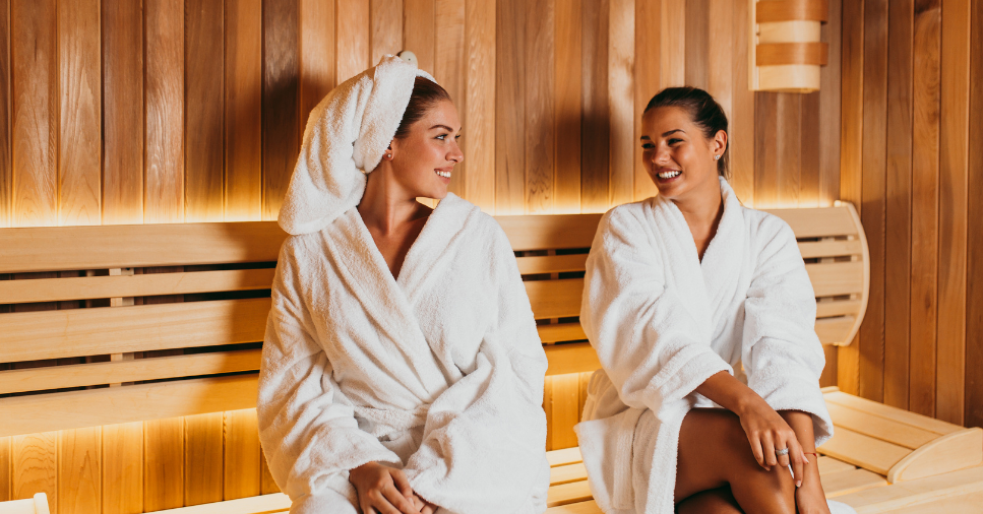 Zwei Frauen im Bademantel entspannen in einer modernen Sauna