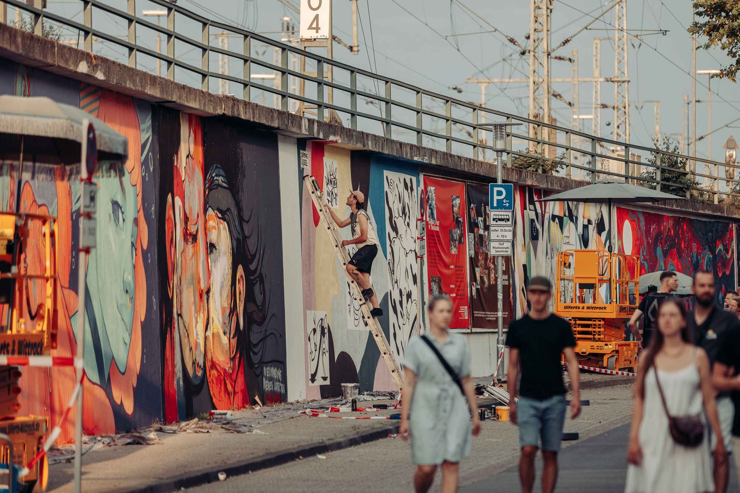 Auf der 250 Meter langen Wand am Bundesbahnweg haben 20 Künstler:innen ihre Werke hinterlassen. Foto: Marcus Windus
