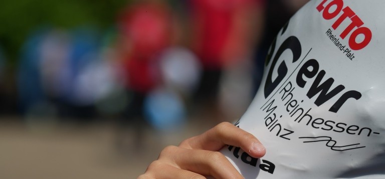 Hand hält ein Schild mit unklarem Text und buntem Hintergrund