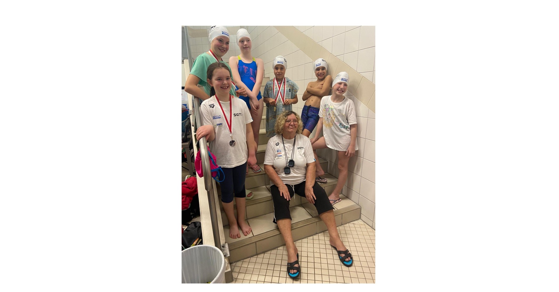 Kinder und Trainer mit Medaillen bei einem Schwimmwettbewerb am 16.11.2025