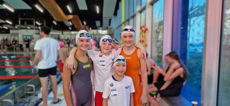 Gruppe von jungen Schwimmern in Arena-Schwimmbekleidung bei einem Wettkampf in der Schwimmhalle