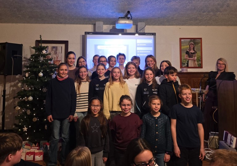 Gruppenfoto einer Schulklasse vor einem interaktiven Whiteboard mit Weihnachtsbaum