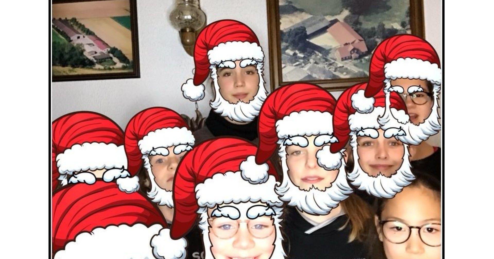 Gruppenfoto mit Weihnachtsmützen bei einer Weihnachtsfeier, Wanddekoration mit Gitarren und Bildern im Hintergrund