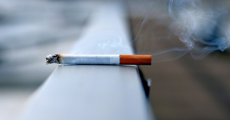 Abgelegte Zigarette – rauchende Zigarette auf einer Oberfläche Abgelegte Zigarette mit Rauch auf einem Metallgeländer Metalloberfläche