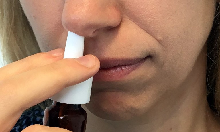 Anwendung von Nasenspray gegen verstopfte Nase Person verwendet Nasenspray zur Linderung von verstopfter Nase