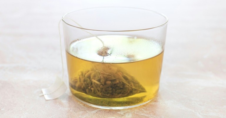 Frischer Tee in einem Glas mit Teebeutel