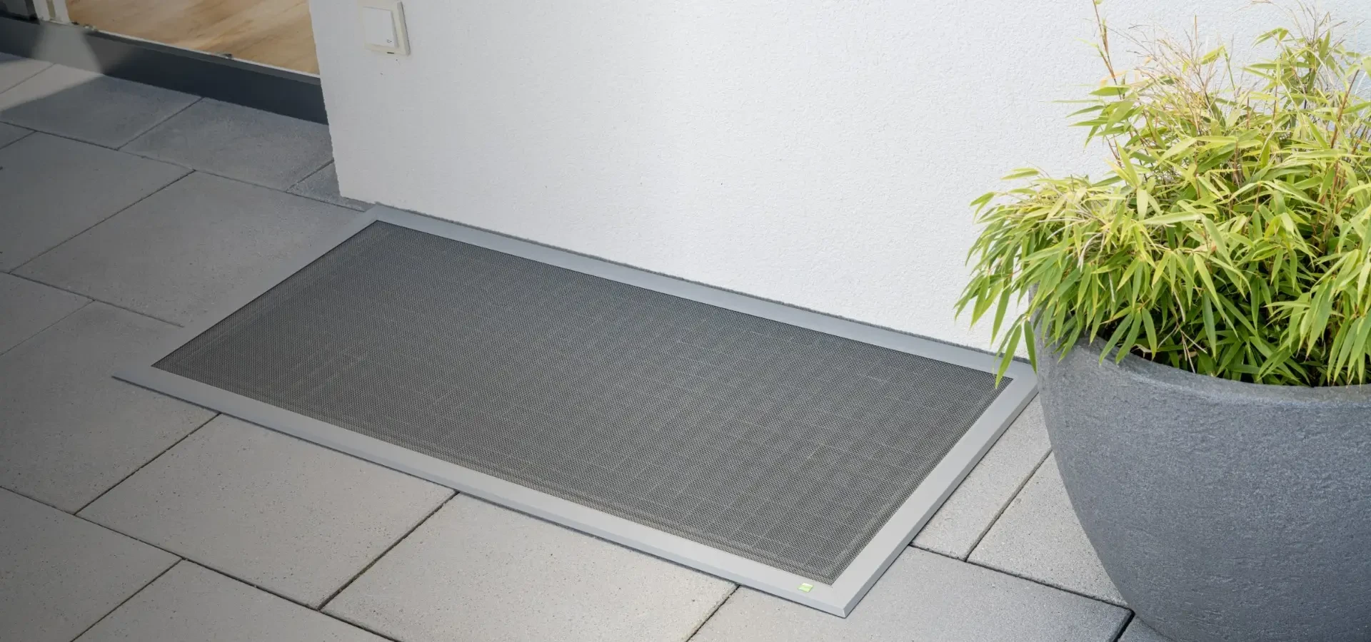 Lichtschachtabdeckung im Bodeneinbau im Außenbereich mit Pflanzen