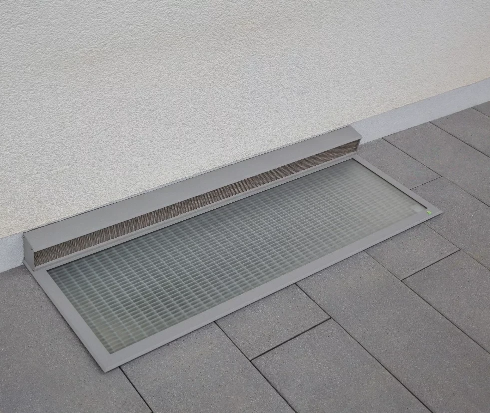 Lichtschachtabdeckung RESI auf einer Terrasse mit grauen Fliesen