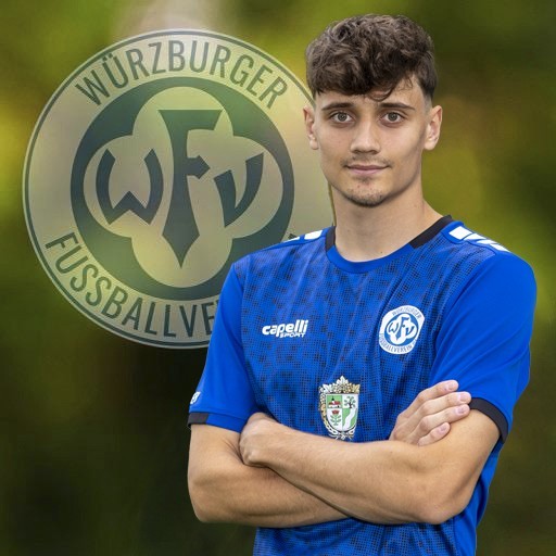Fußballspieler des Würzburger FV im blauen Trikot vor dem Vereinslogo Spieler im blauen Würzburger FV Trikot vor Vereinslogo