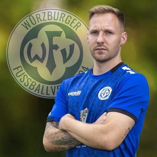 Fußballspieler des Würzburger FV mit Vereinslogo im Hintergrund Fußballspieler des Würzburger FV in blauem Trikot vor Vereinslogo